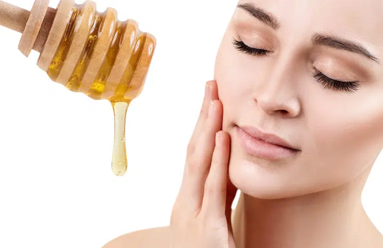 Young woman prepare for honey facial mask. Isolated on white background.