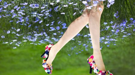 Beautiful female legs wearing shoes decorated with flowers and f