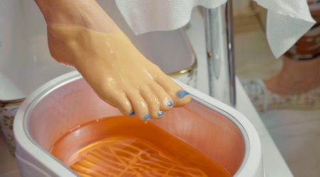 Wax bath for feet at beauty spa salon, close-up. Wax bath for feet at beauty spa salon, close-up. Paraffin wax treatments for feet.