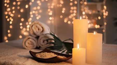 Plate With Sea Salt And Burning Candles On Table In Spa Salon