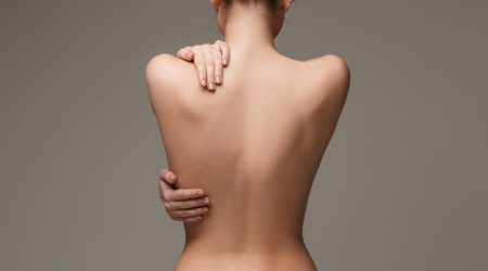 beautiful woman's body on gray background. The nude woman back
