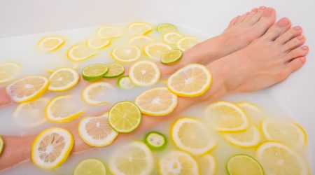 Girl takes a milk bath with lemons and limes. Citrus spa. Body care. Skin whitening. Women’s feet. Girl takes a milk bath with lemons and limes. Citrus spa. Body care. Skin whitening. Women's feet